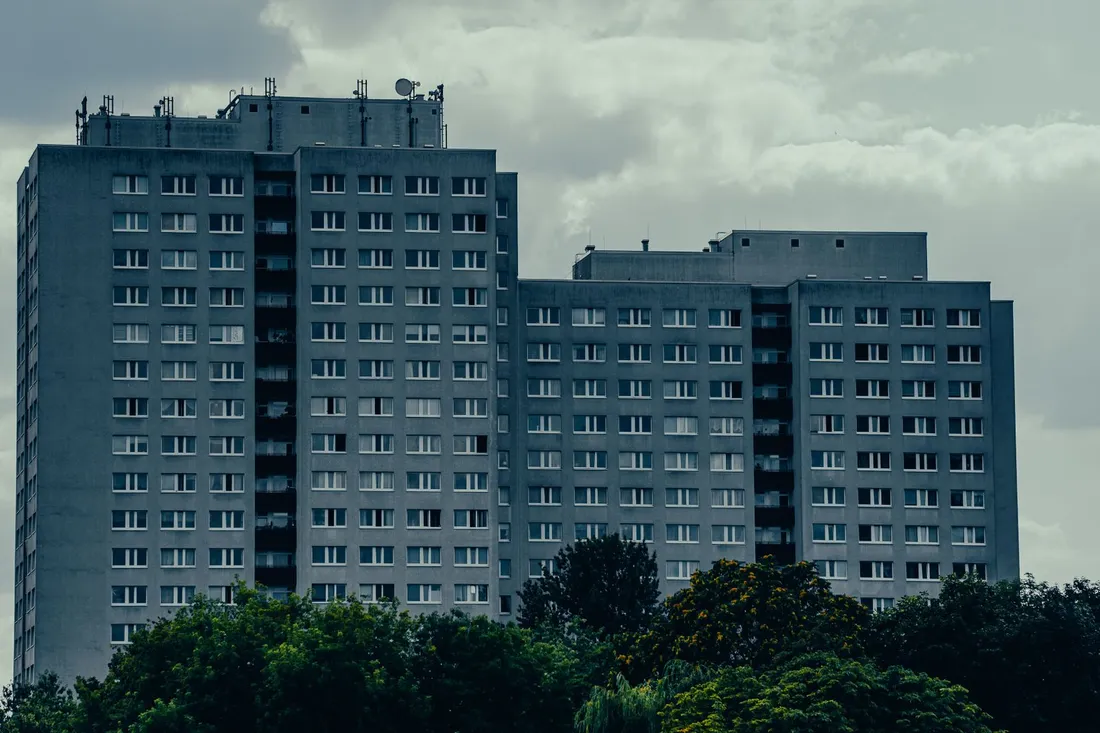Hohes Plattenbau-Wohnhaus mit vielen Etagen vor blauem Himmel