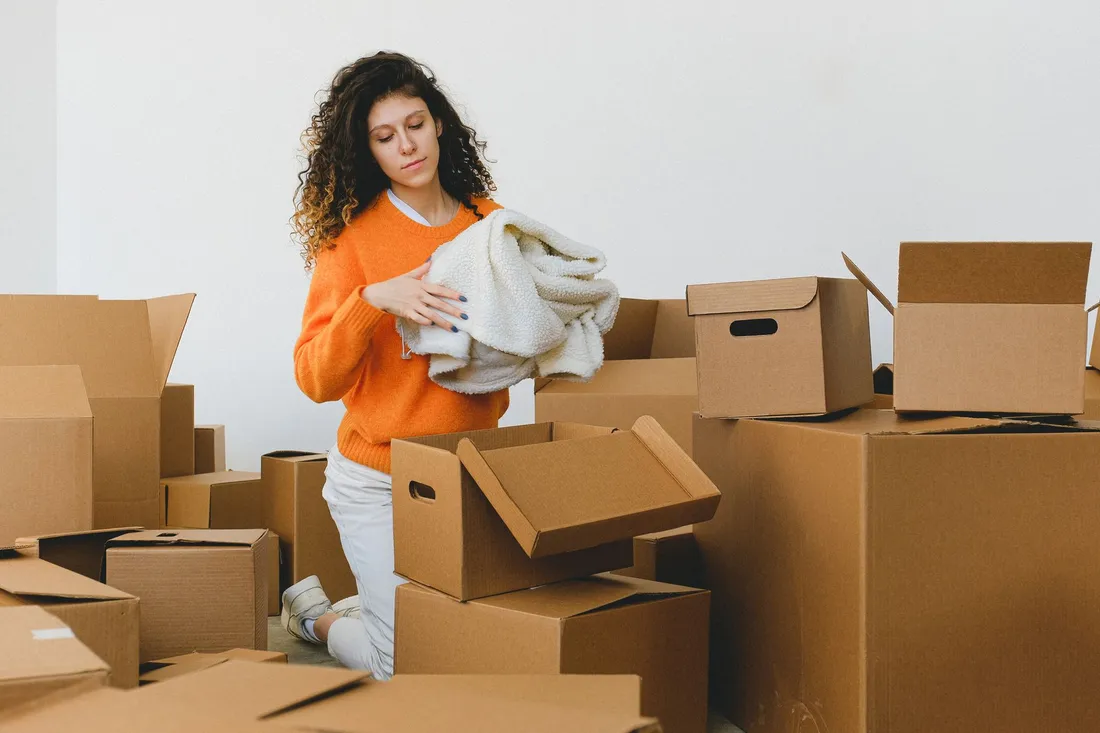Umzugskartons und Möbelteile in einer Wohnung beim Packen